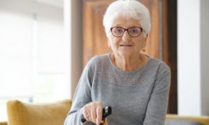 Blije oudere dame in haar woonkamer