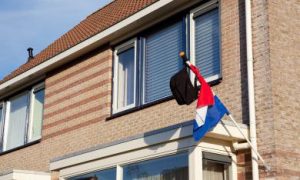 rugtas hangt aan de vlag buiten bij geslaagde examenkandidaat