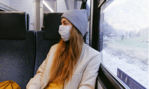 vrouw met mondkapje in trein