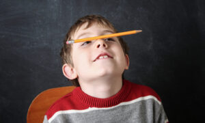 jongen met potlood op de neus in de klas