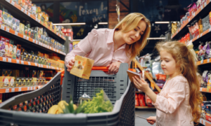 Beeld van moeder die met haar dochter boodschappen doet